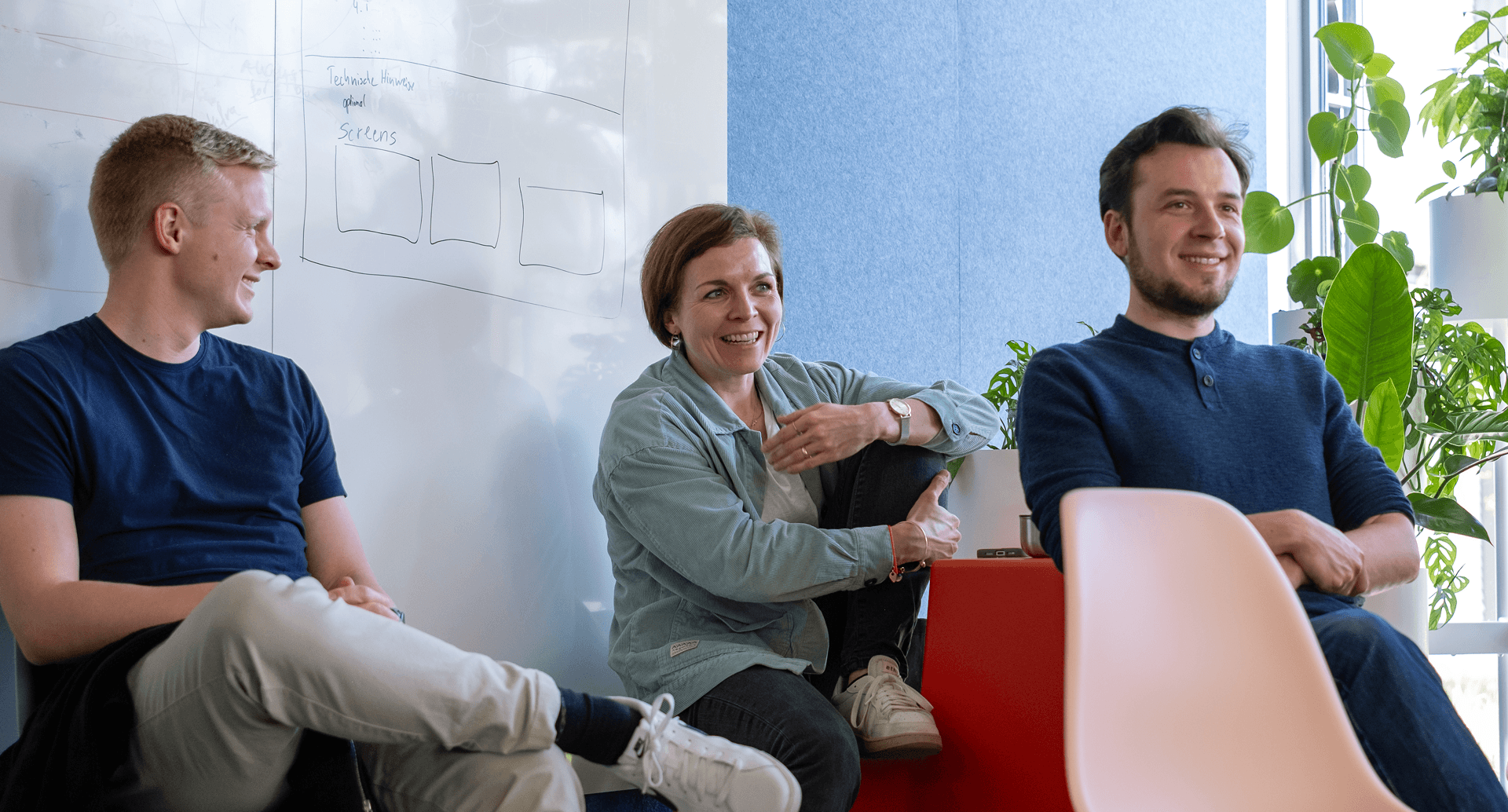 Lachende Mitarbeitende in einer Meetingsituation