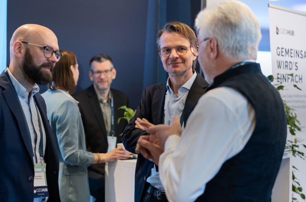 Mehrere Personen stehen am Messestand und unterhalten sich