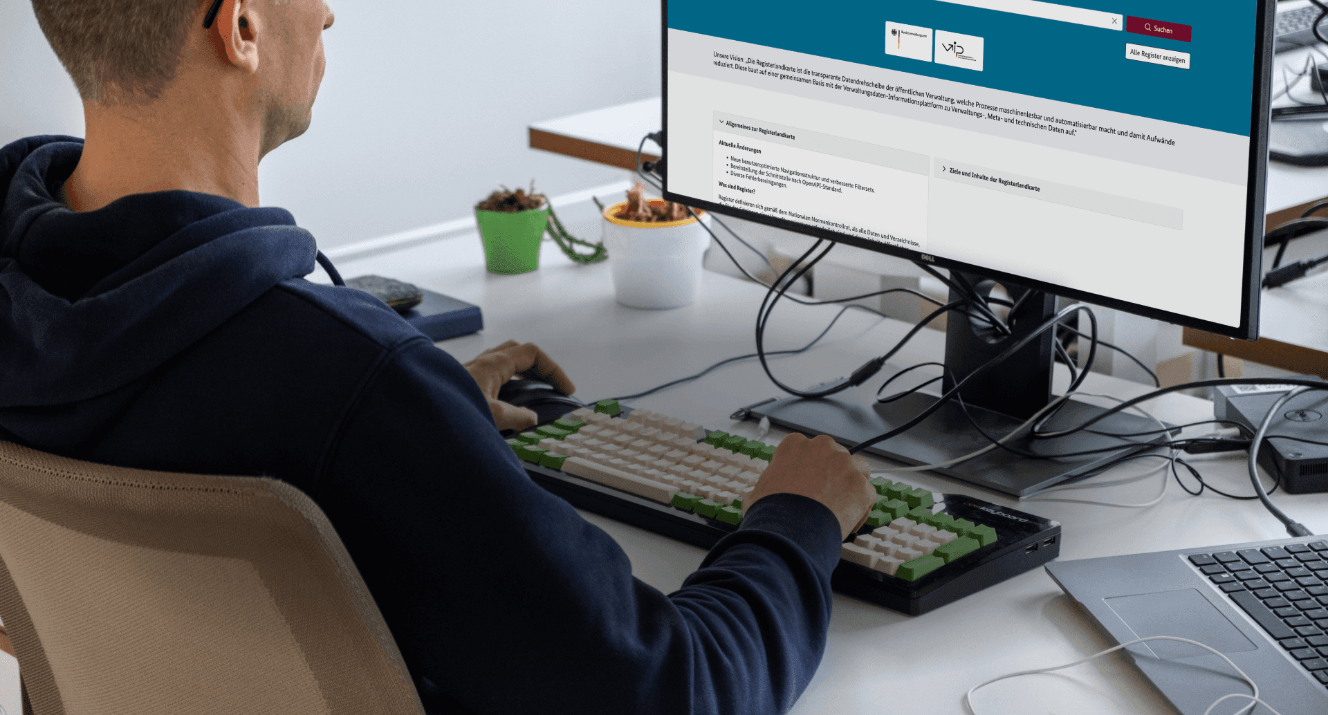 Ein Mann sitzt an einem Computer. Auf dem Bildschirm ist eine Webseite der Registermodernisierung geöffnet.