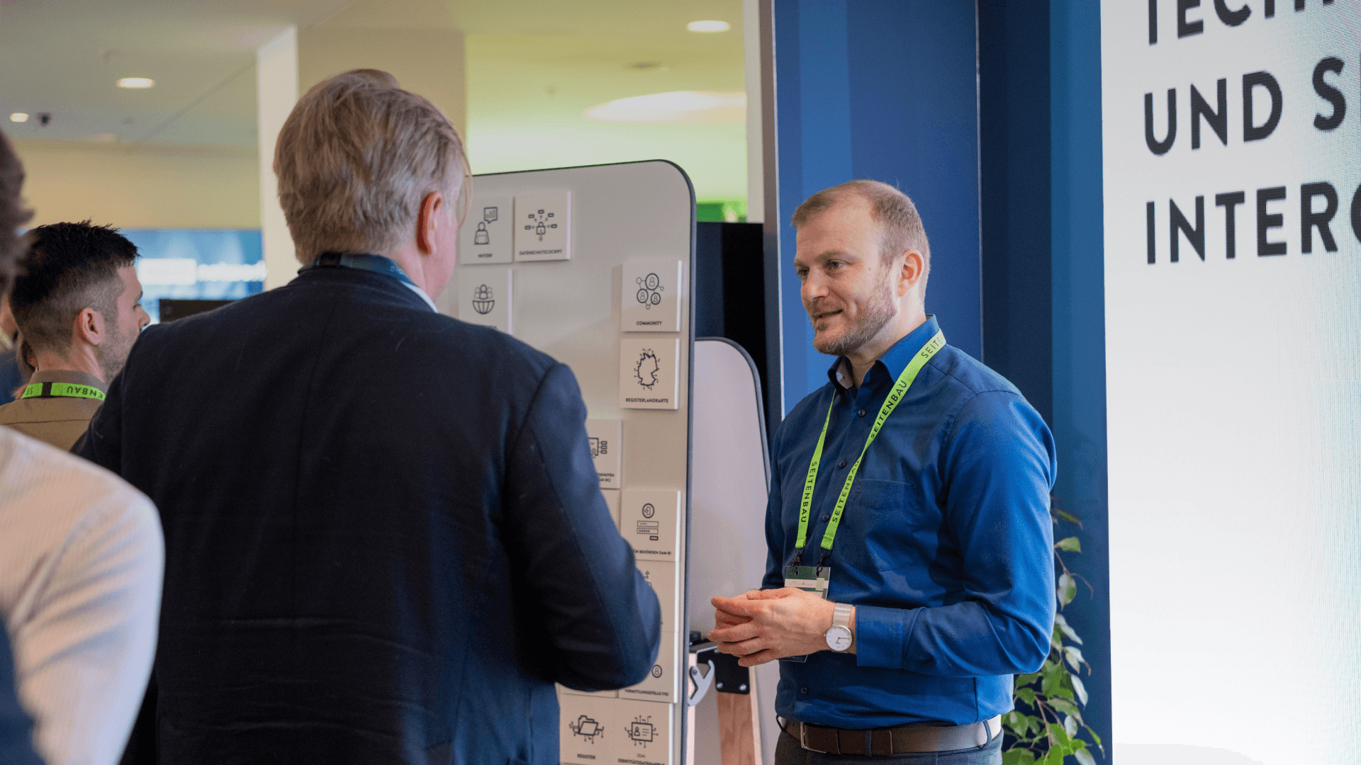 Mehrere Personen stehen am Messestand und unterhalten sich