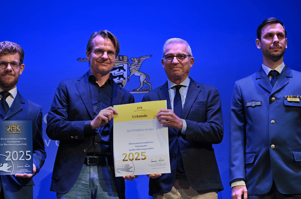 SEITENBAU-Geschäftsführer Stefan Eichenhofer, Thomas Strobel, Innenminister des Landes Baden-Württemberg und zwei SEITENBAU-Kollegen in THW-Uniform bei der Preisverleihung