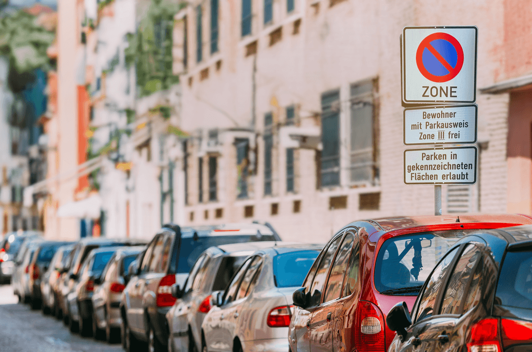 Man sieht eine Reihe von geparkten Autos und ein Schild, das den Bereich als Anwohnerparkzone kennzeichnet